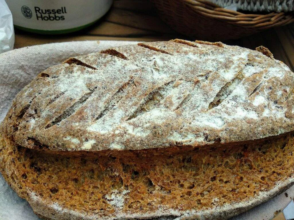 Sok magvas gluténmentes kenyér egy szakajtóban, virágmintázatú bevágással