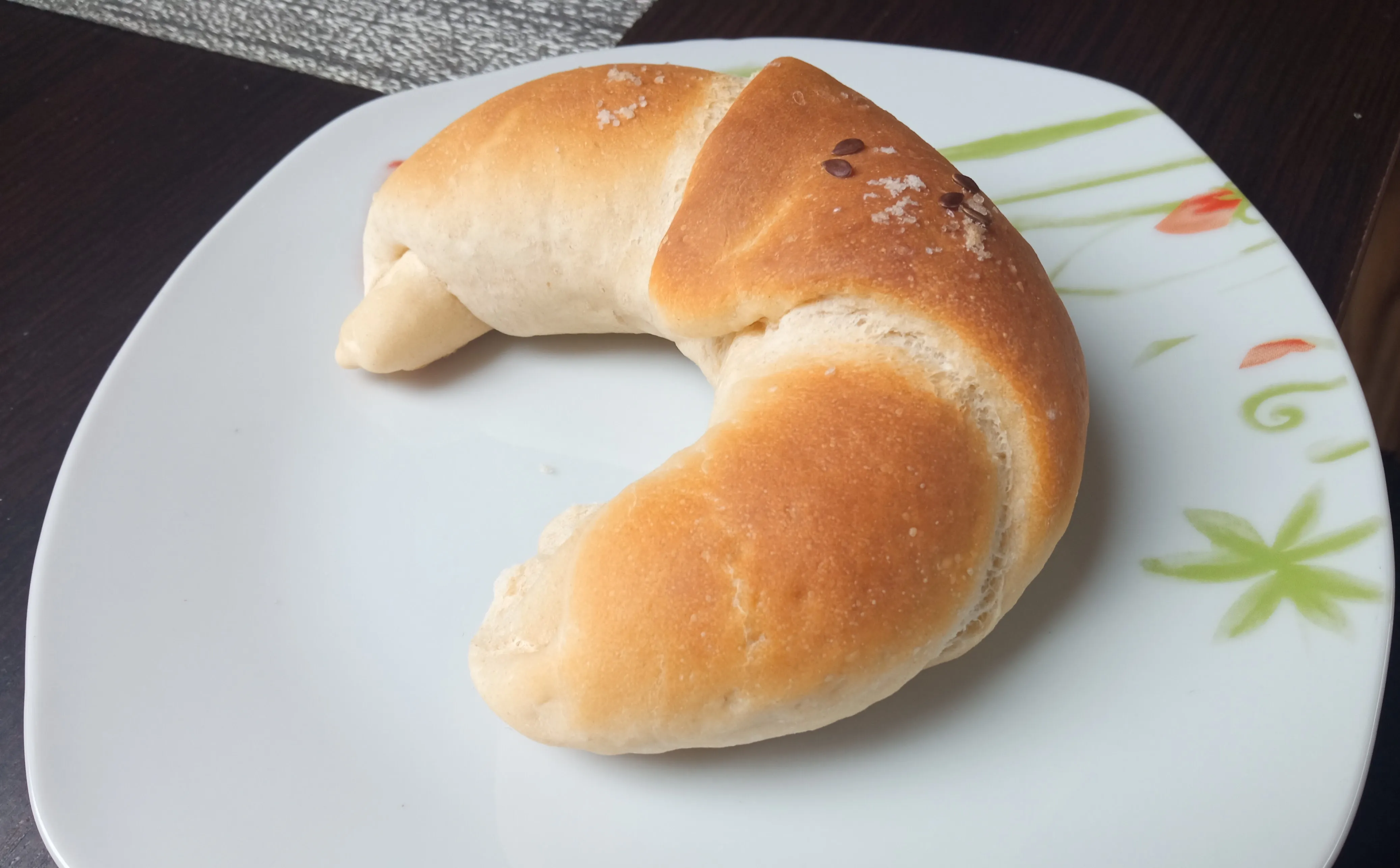 Lenmaggal és sóval megszórt kifli reggelire, tányéron felszolgálva